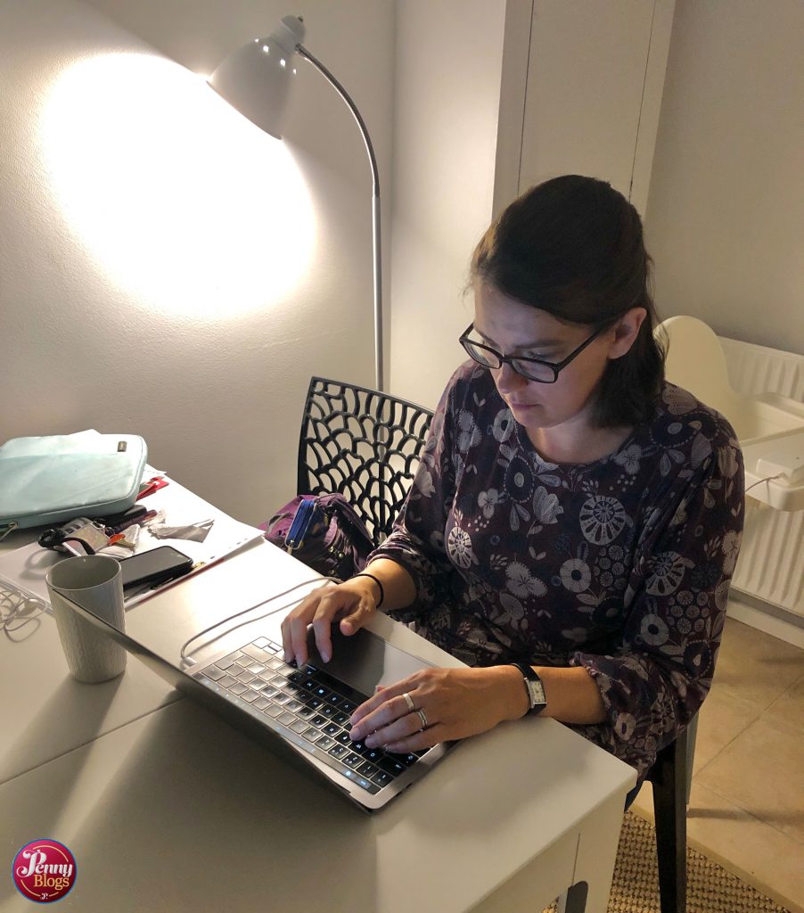 Penny working on her laptop whilst sat at a table in an Airbnb in Copenhagen. Photo to accompany an article on the Three App.
