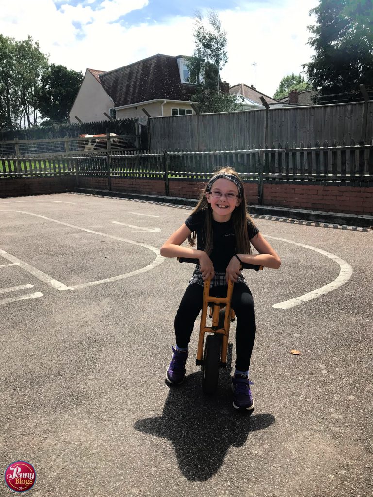 A girl sat on a small balance bike at Woodside Animal Farm