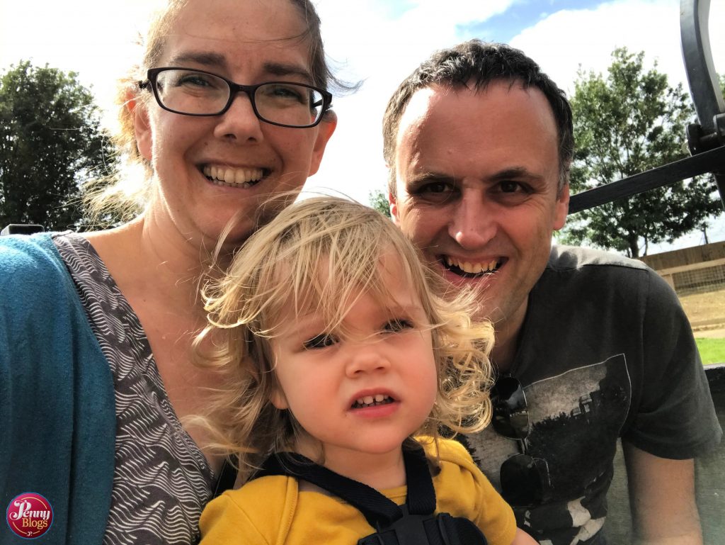 A family group of two adults and one toddler on the tractor at Woodside Animal Farm