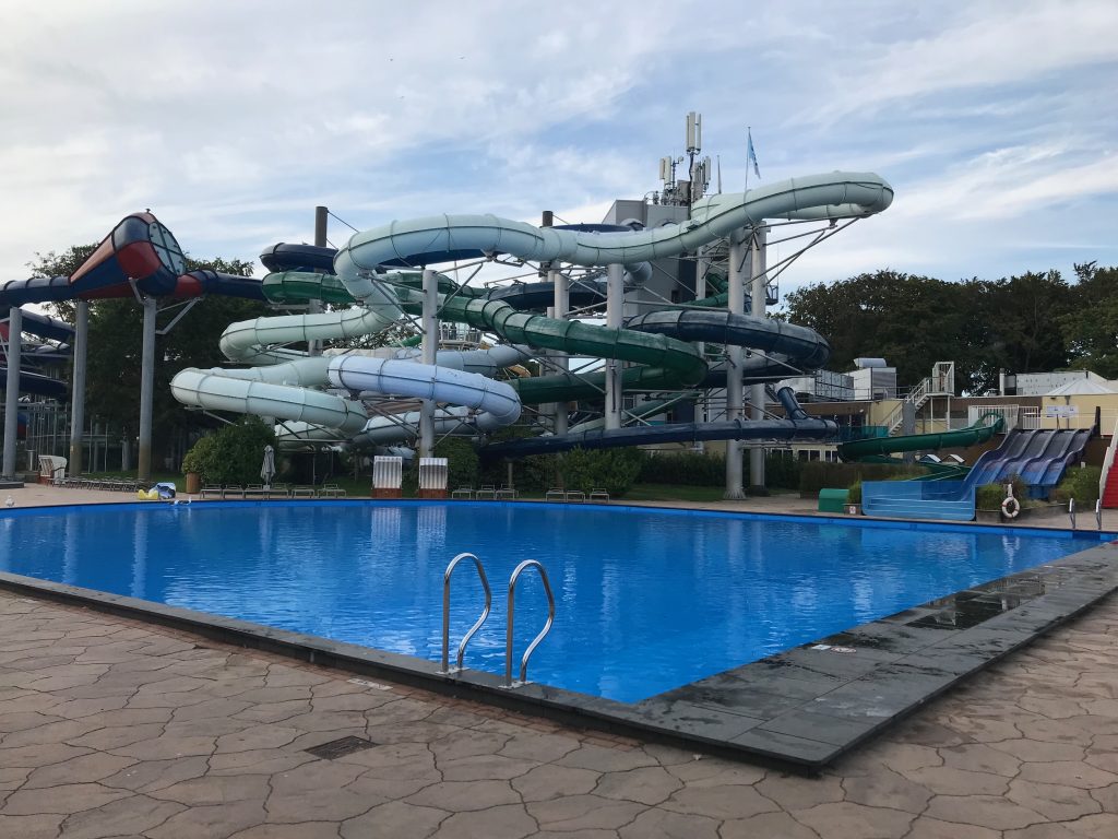 A view over the main outdoor pool at Duinrell, showing the indoor pool's slides in the background.