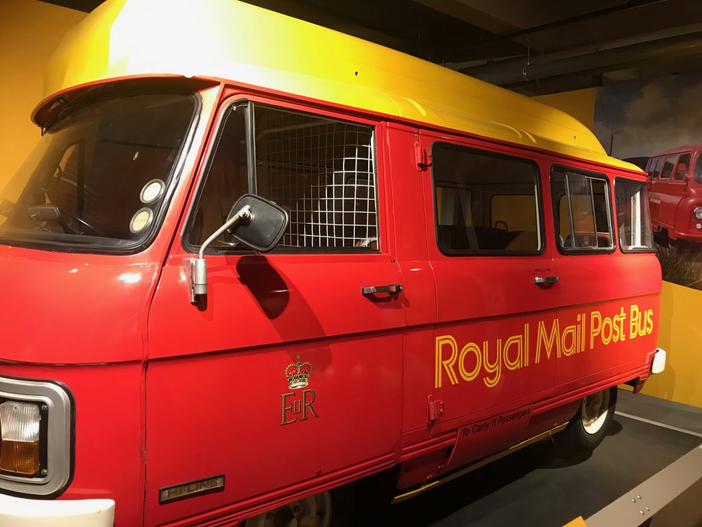 A very cute and cheery looking red and yellow Royal Mail Post Bus.