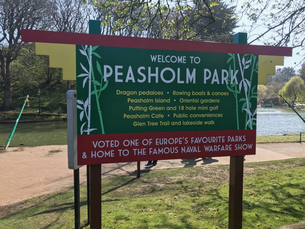 The sign for Peasholm Park listing what there is to do there. At the bottom it says "Home to the Famous Naval Warfare Show"