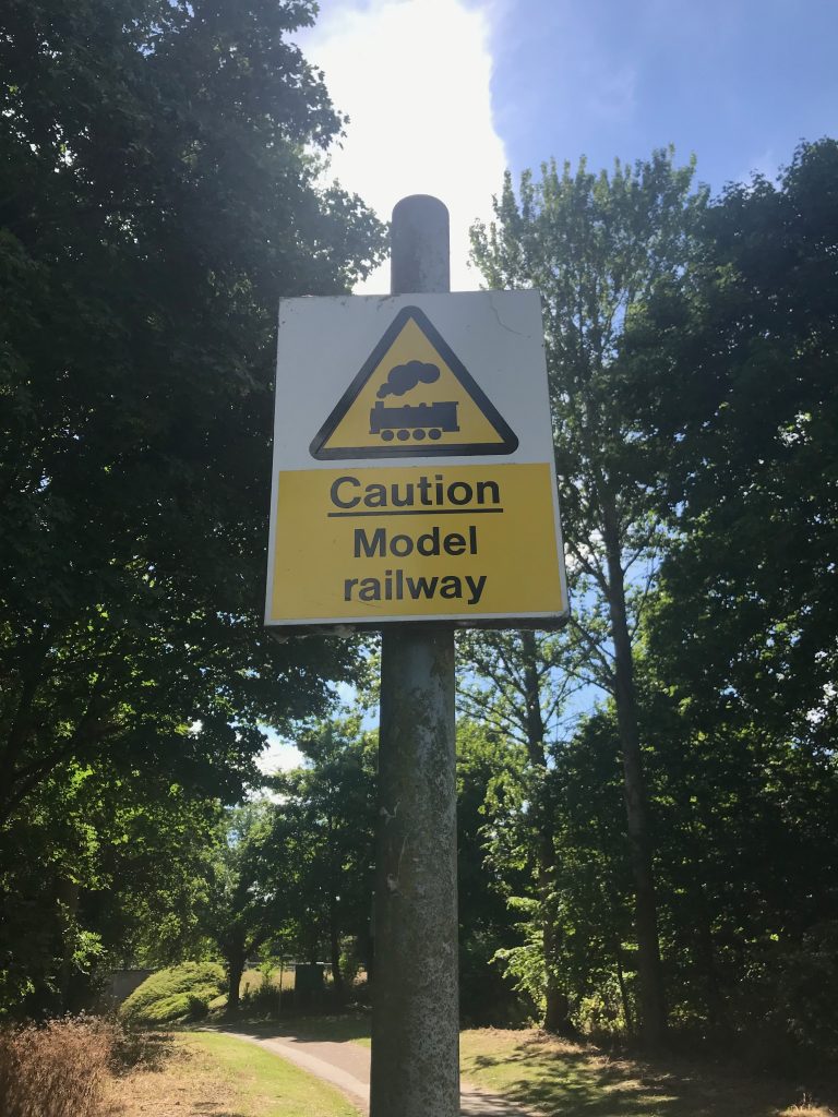 A yellow warning sign showing an picture of a steam train and the words "Caution Model railway"